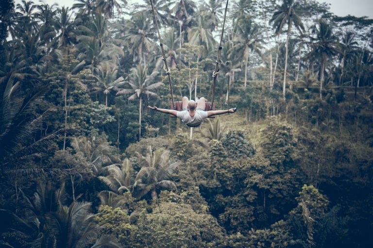 BALI, INDONESIA. Man having fun on the swing.